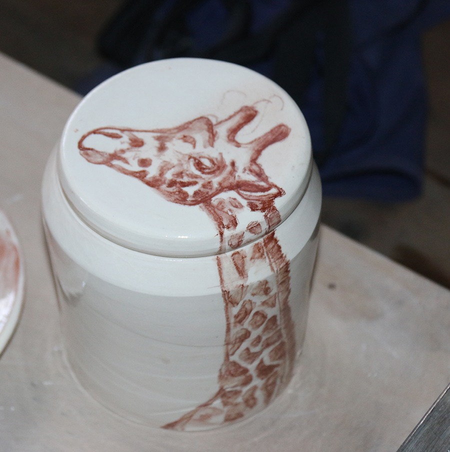 Boite illustrée d'une girafe réalisée à la craie d'oxydes rouge sur fond blanc à l'engobe.